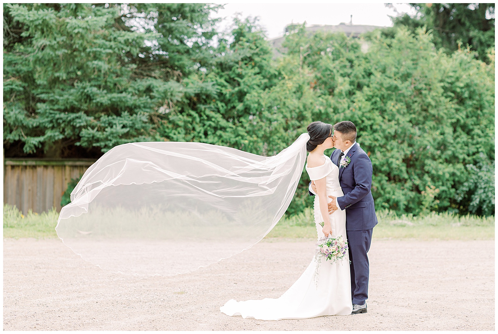Couple kissing veil blowing in wind