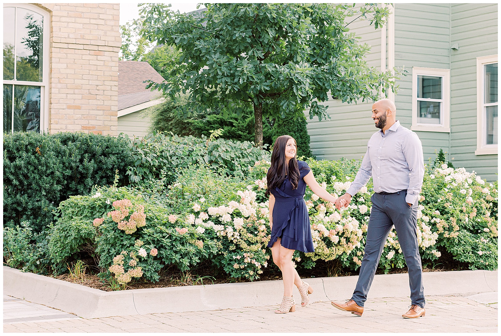 Couple smiling and walking by flowers