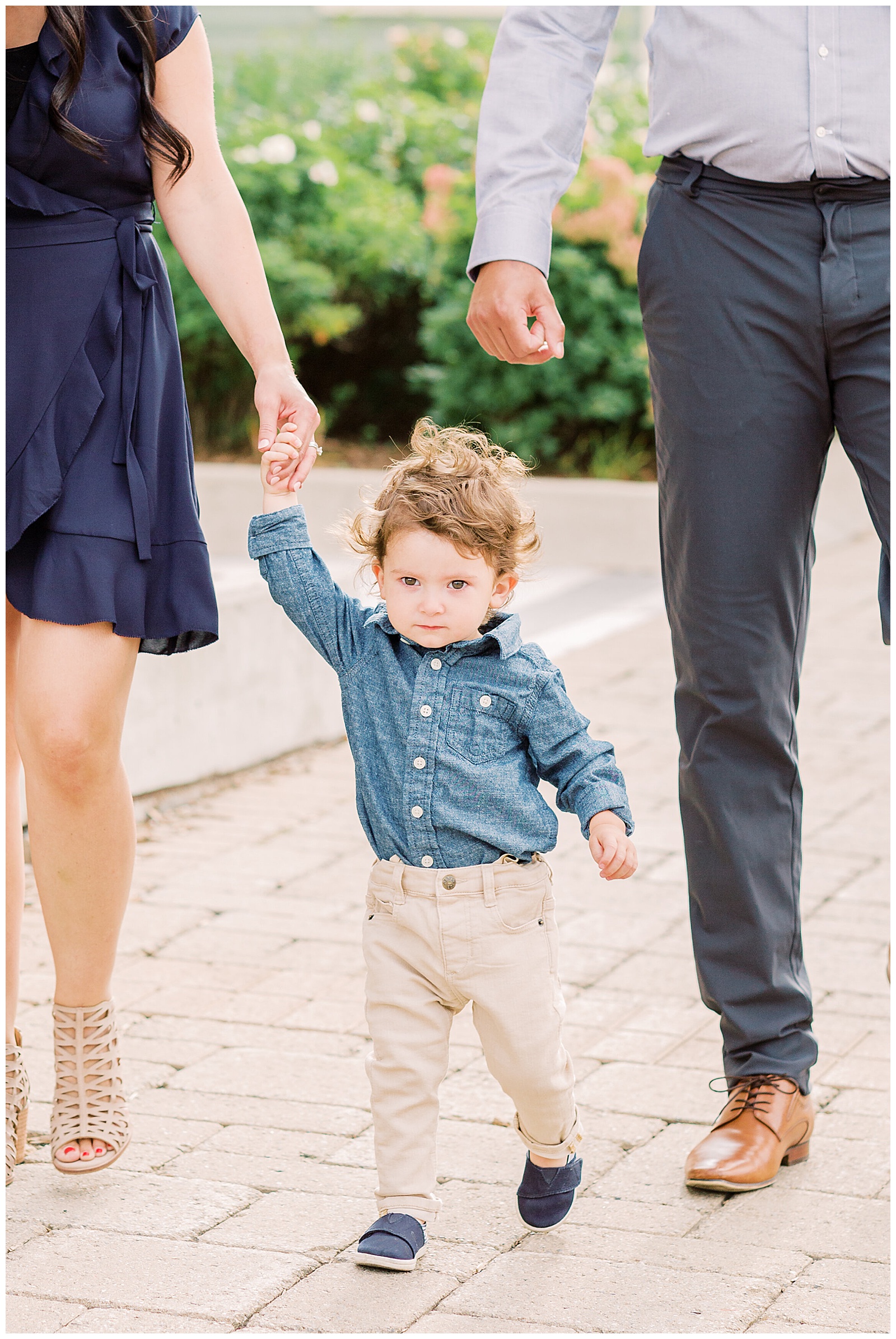 Small boy holding mom's hand while walking