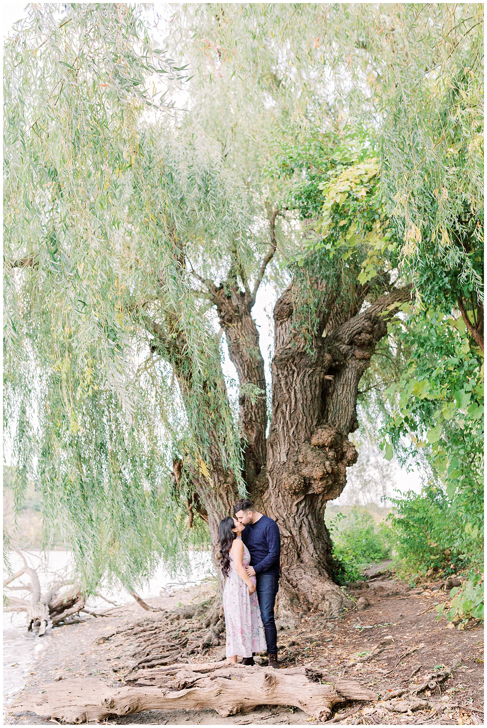 Couple Kissing under willow tree at Princess Point Maternity Session