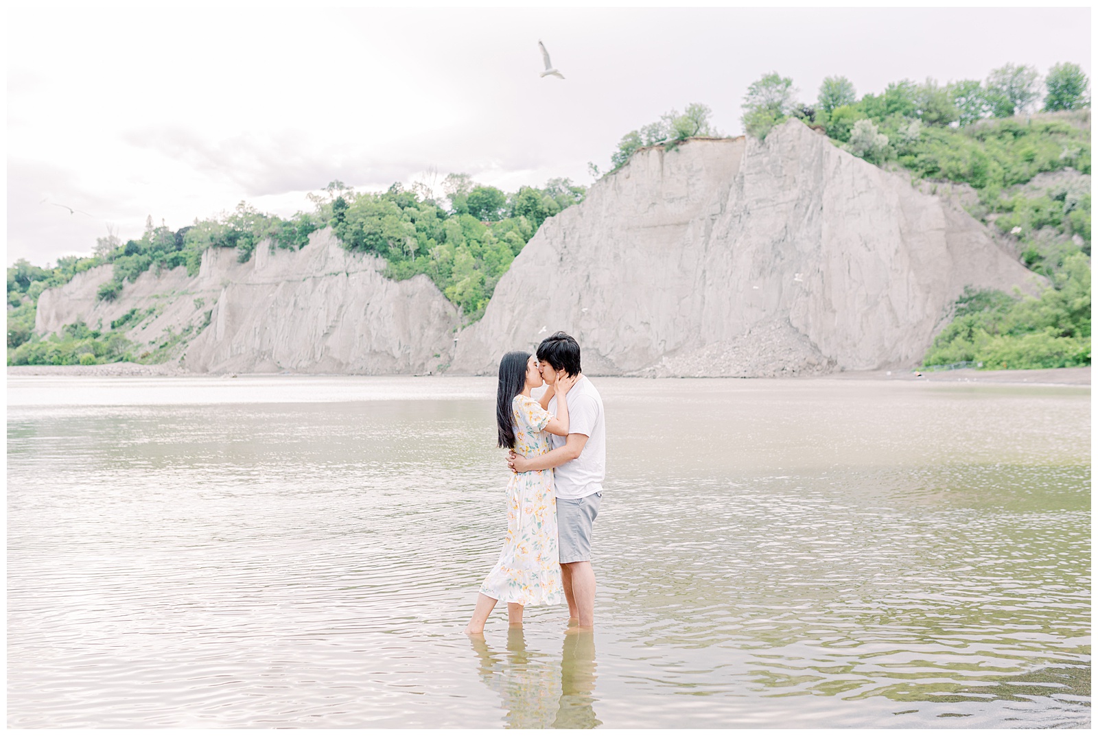 Couple kissing at Scarborough Bluffs, seagull flying overhead